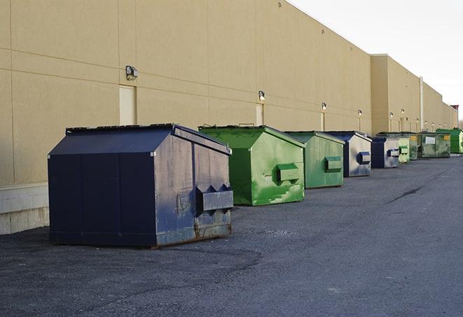 a row of blue construction dumpsters on a job site in Anderson